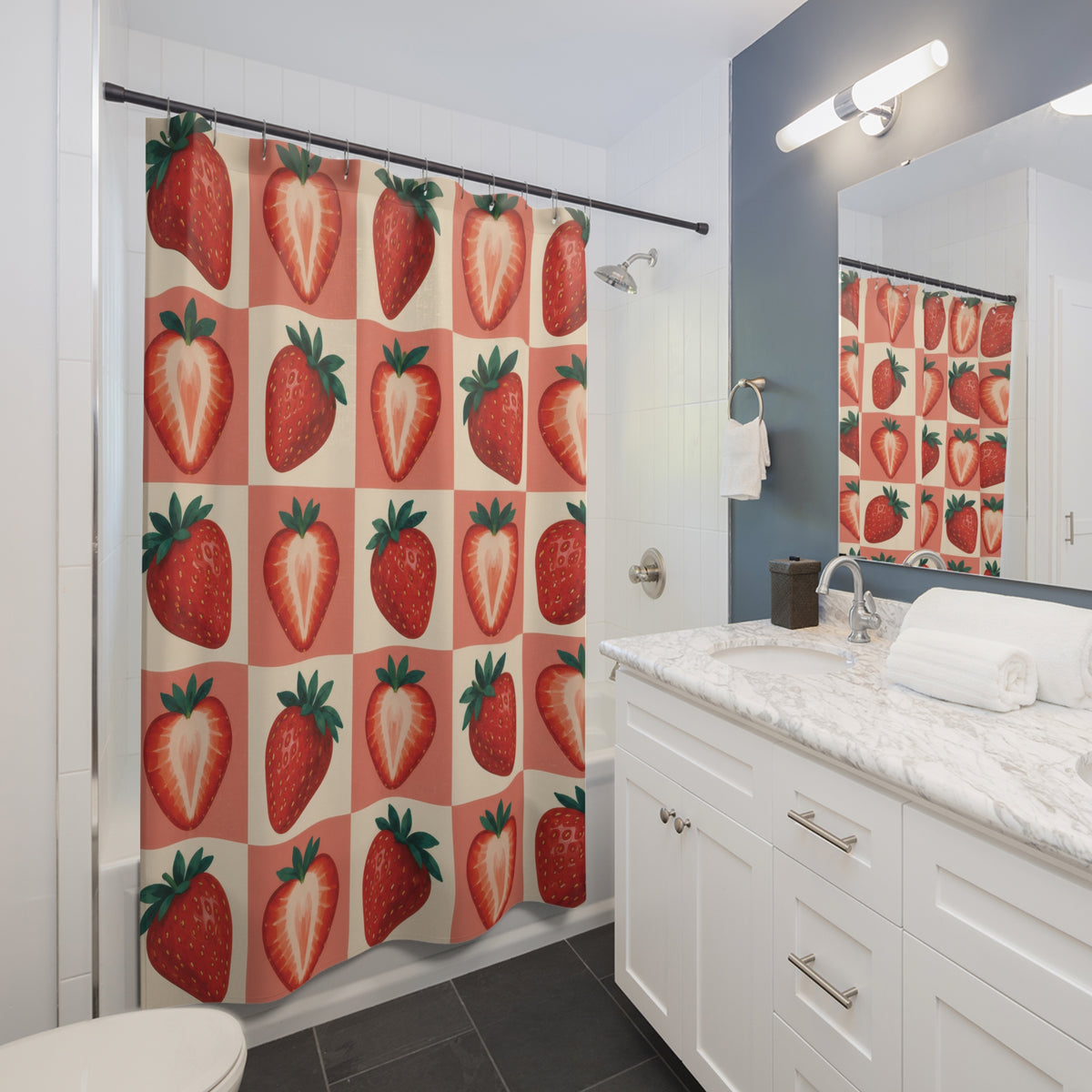 Red strawberries on coral and cream checks shower curtain beside a white vanity