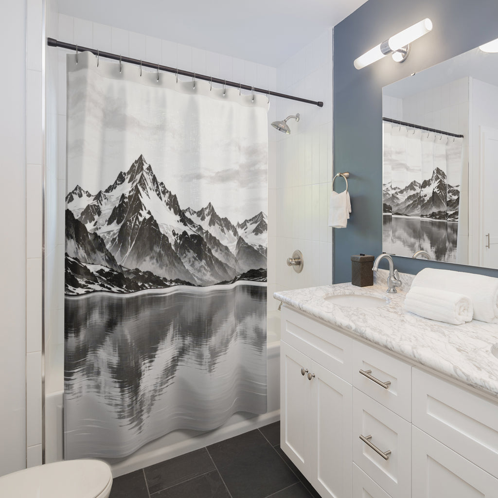 Snowy black and gray mountains reflected in a pale lake shower curtain beside a white vanity