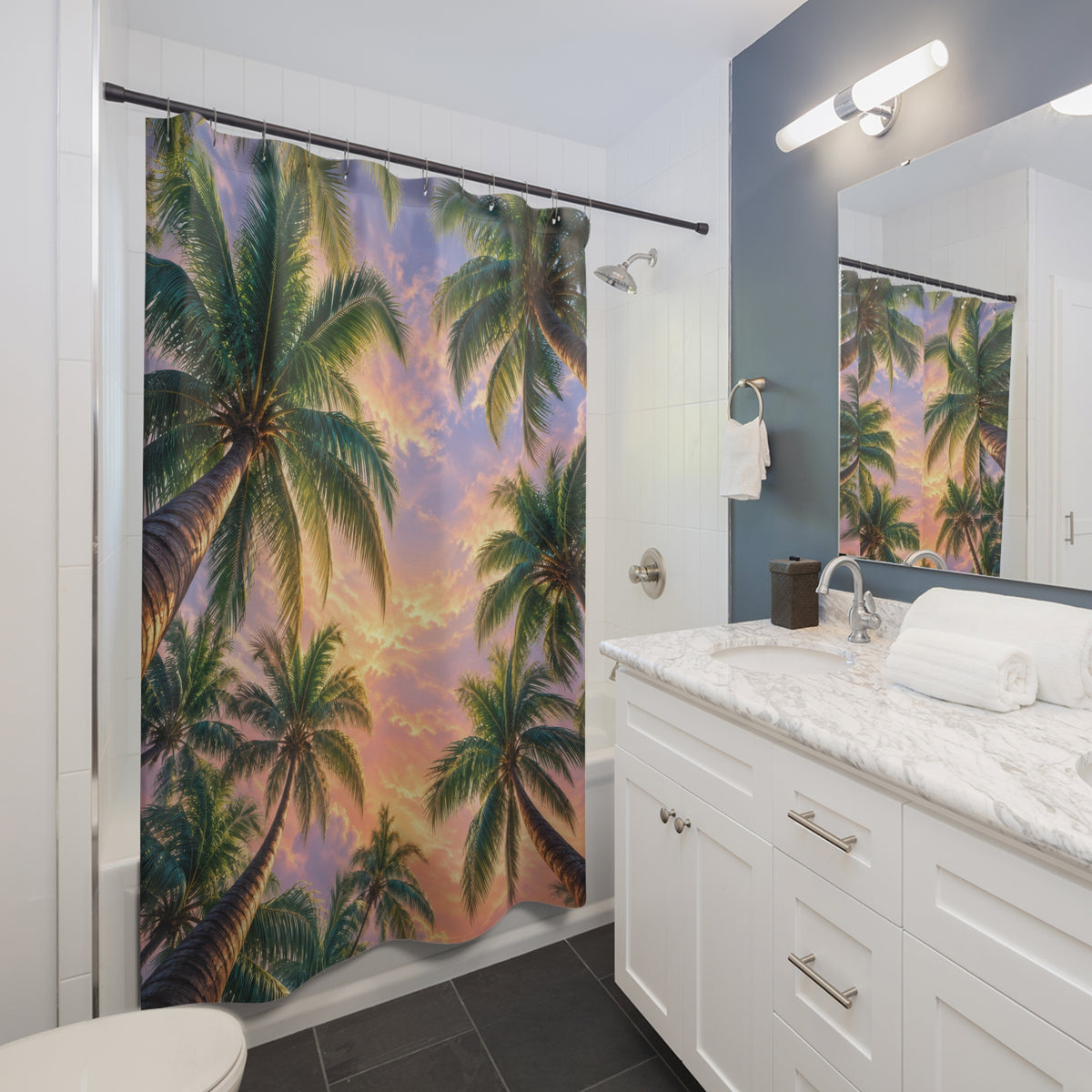 Green palm canopy around a pink and lavender sunset sky shower curtain beside a white vanity