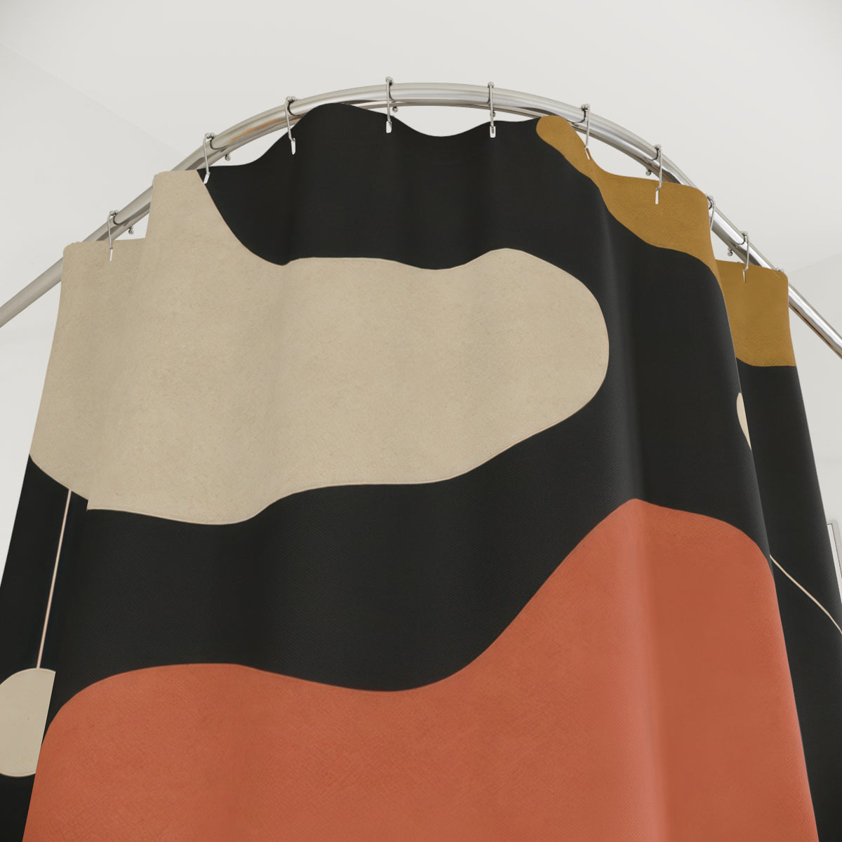 Cream, coral and ochre kidney shapes on charcoal shower curtain with close-up print, hooks, and folds