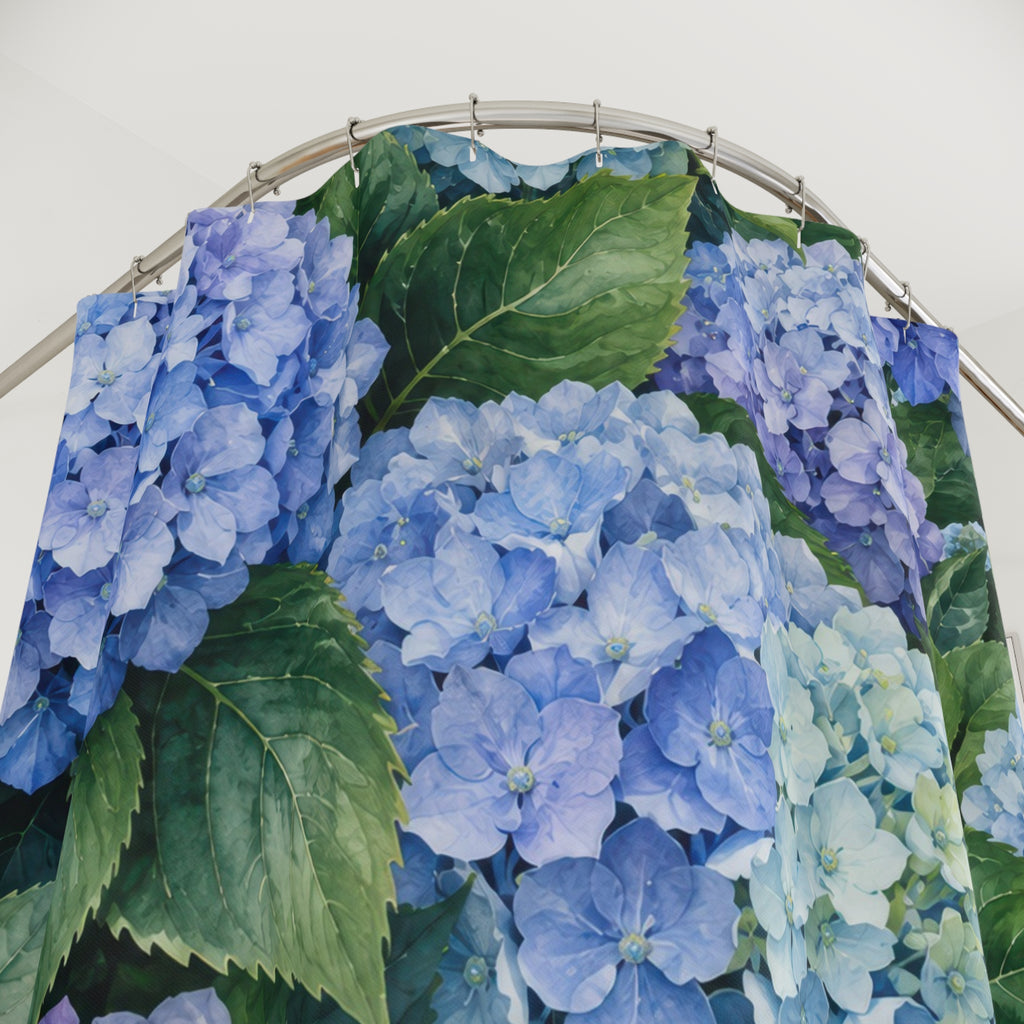 Blue hydrangea clusters among broad green leaves shower curtain with close-up print, hooks, and folds
