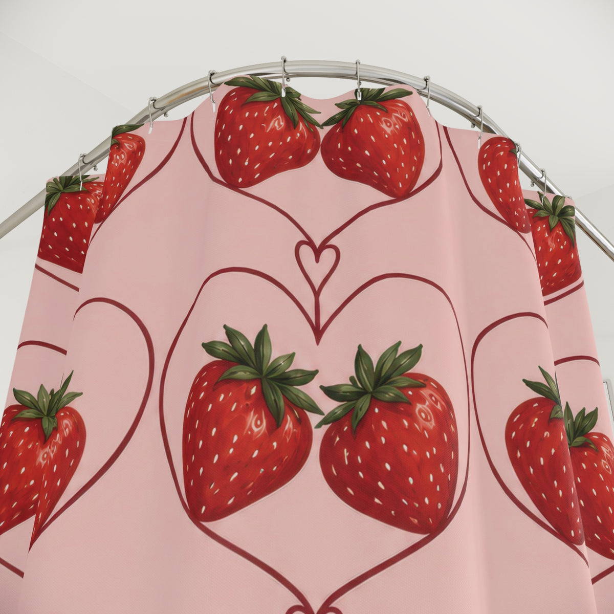 Red strawberry pairs in burgundy hearts on blush pink shower curtain with close-up print, hooks, and folds