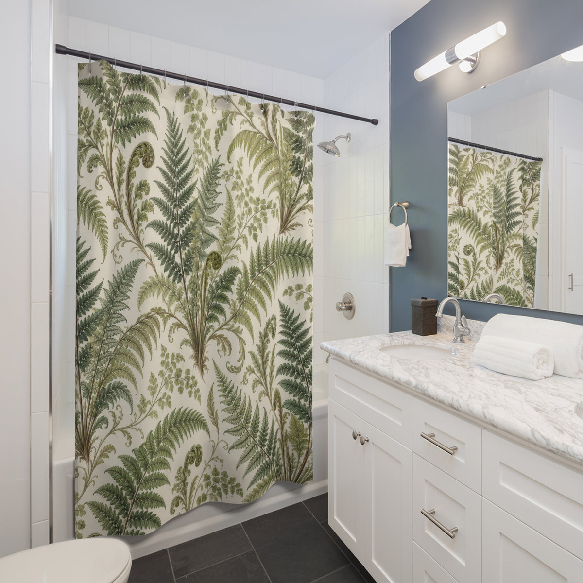 Green fern fronds and curled fiddleheads on ivory shower curtain beside a white vanity