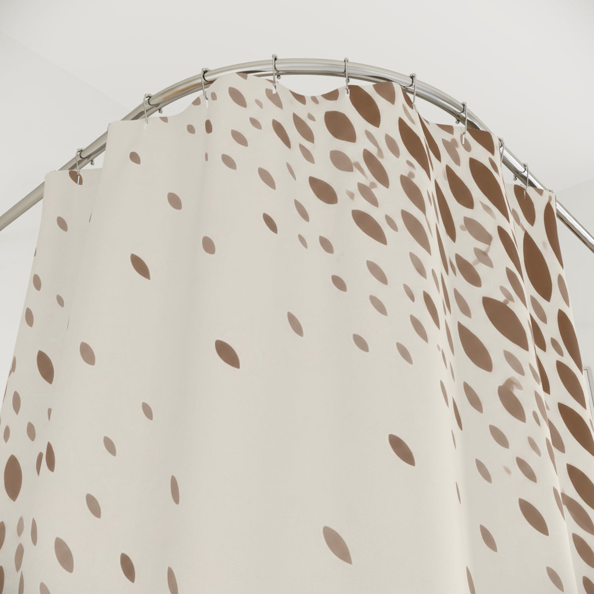 Brown and taupe fawn spots framing an ivory diagonal opening shower curtain with close-up print, hooks, and folds