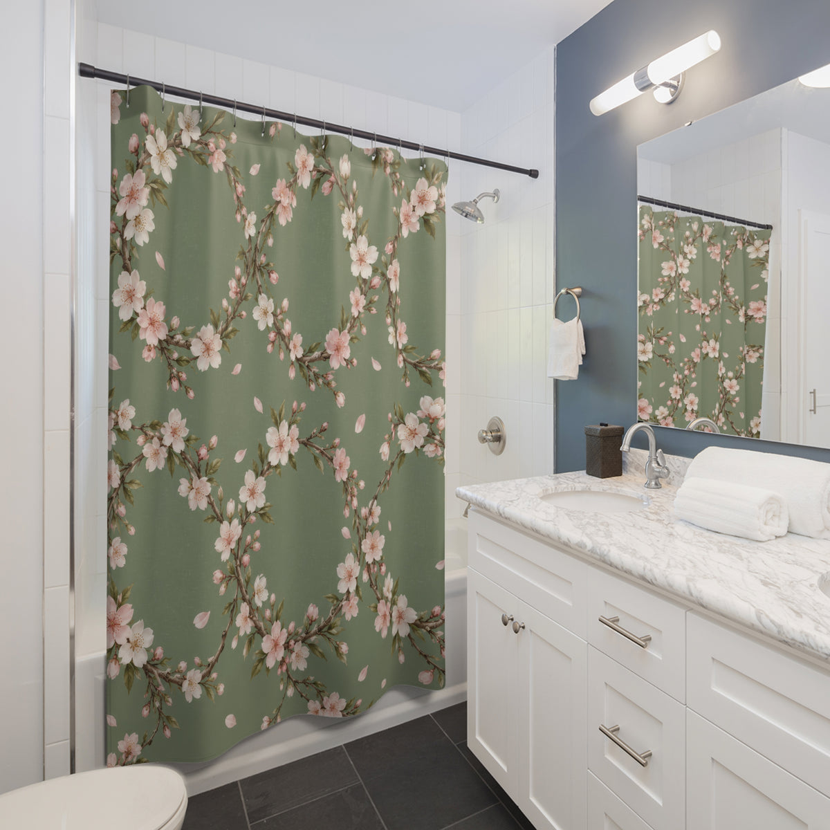 Cream and pink cherry blossom wreaths on sage green shower curtain beside a white vanity
