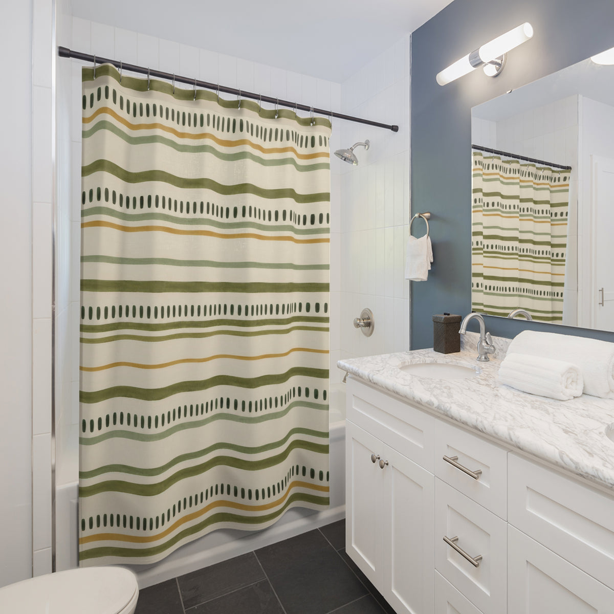 Olive and sage lines with forest-green dash rows on cream shower curtain beside a white vanity