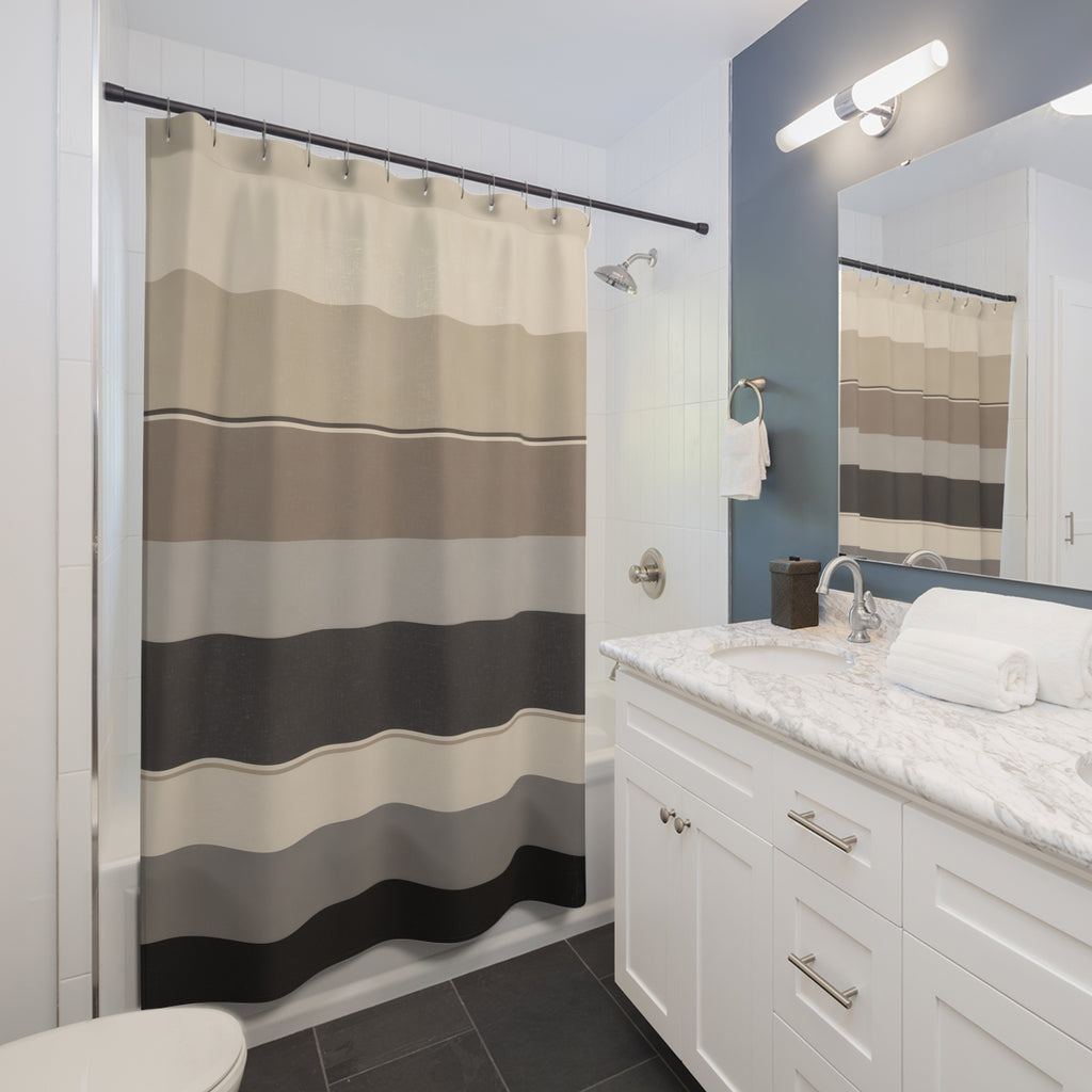 Wide horizontal stripes in cream oatmeal taupe gray and charcoal shower curtain beside a white vanity