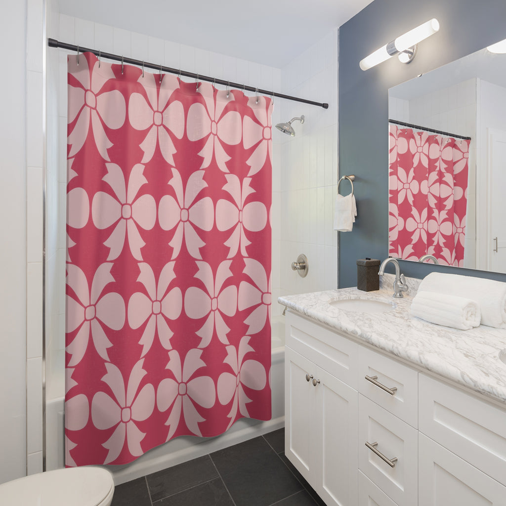 Pale pink bow ornaments on strawberry pink shower curtain beside a white vanity