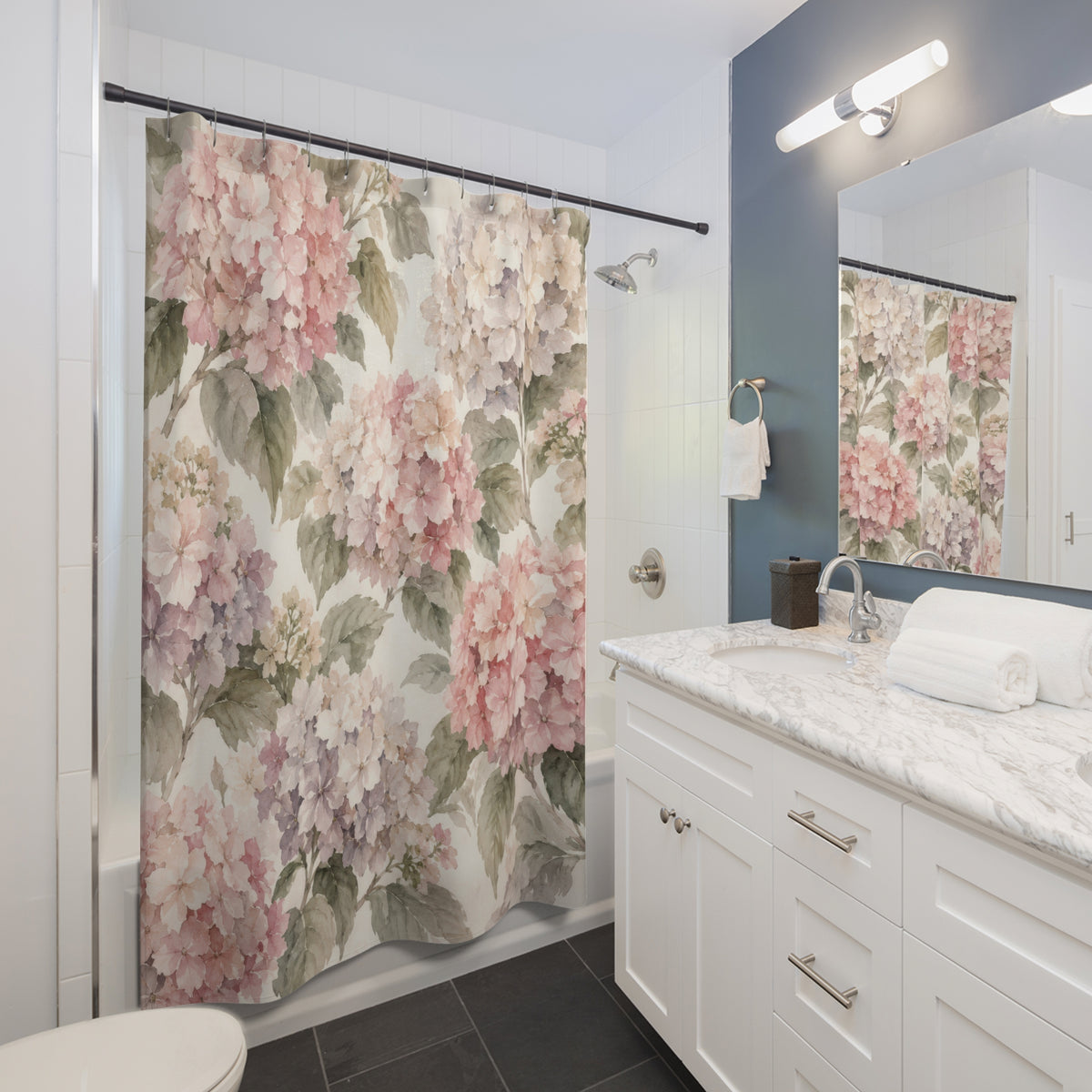 Blush hydrangeas and sage leaves on cream shower curtain beside a white vanity