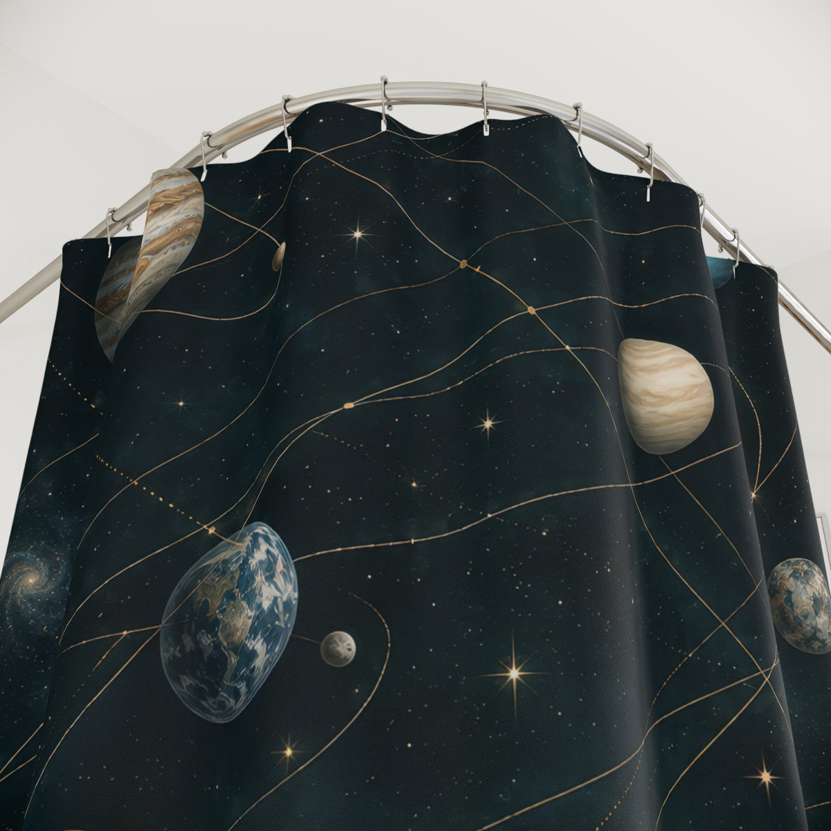Blue and cream planets along gold orbits on dark teal shower curtain with close-up print, hooks, and folds