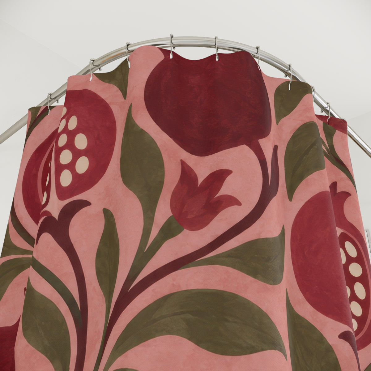 Pink and burgundy pomegranates with olive leaves on rose shower curtain with close-up print, hooks, and folds