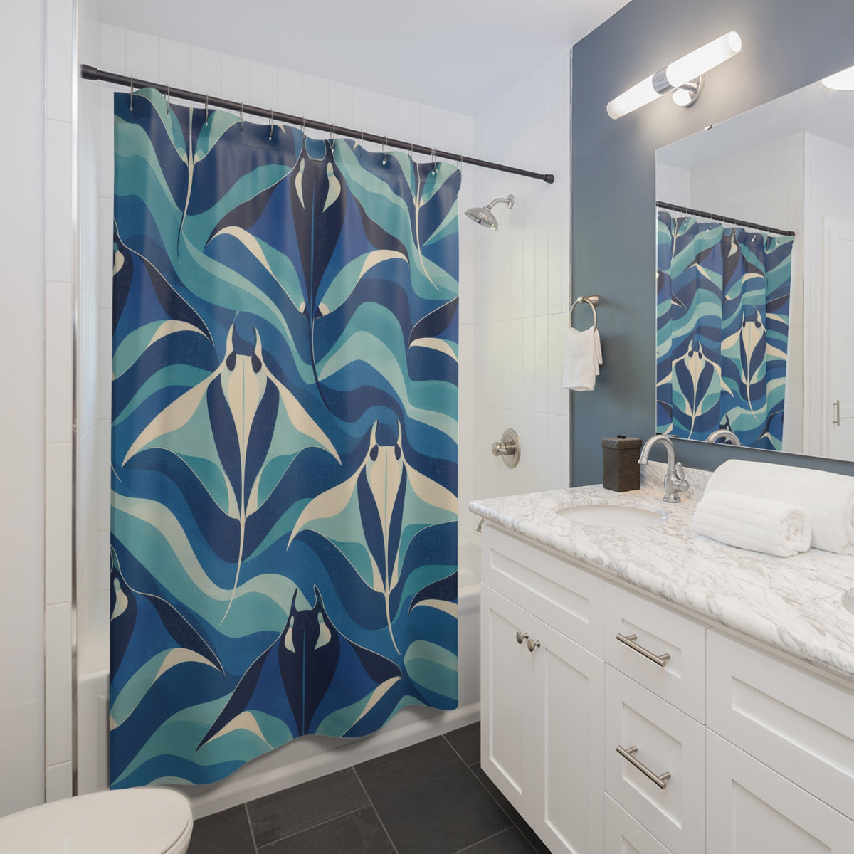 Navy and cream manta rays among blue and aqua wave bands shower curtain beside a white vanity