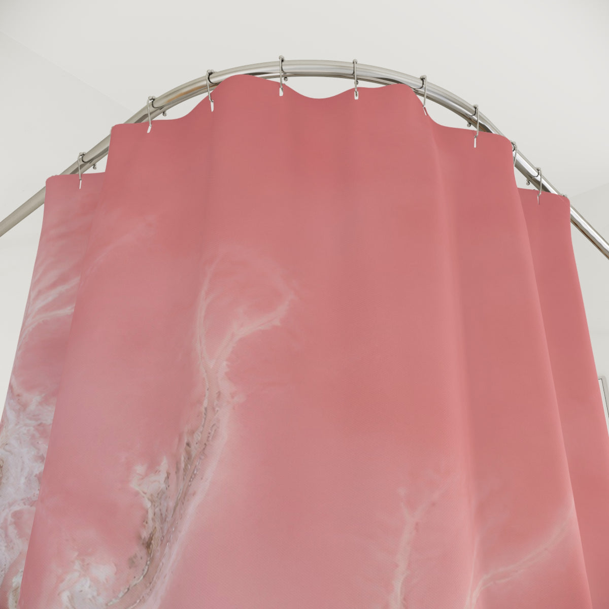 Aerial blush pink salt lagoon and branching white shore shower curtain with close-up print, hooks, and folds