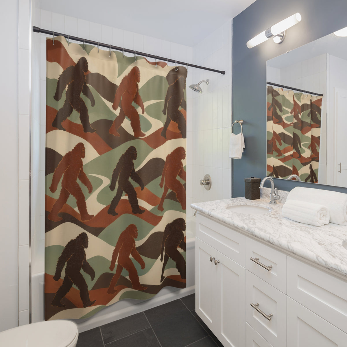 Brown and rust Bigfoot figures among sage and ivory ridges shower curtain beside a white vanity
