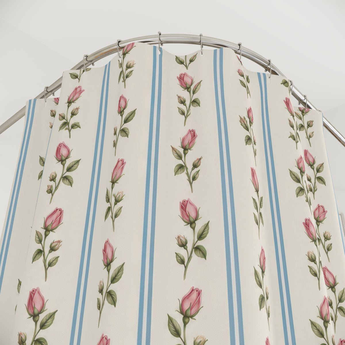 Pink rosebud columns with paired blue lines on ivory shower curtain with close-up print, hooks, and folds