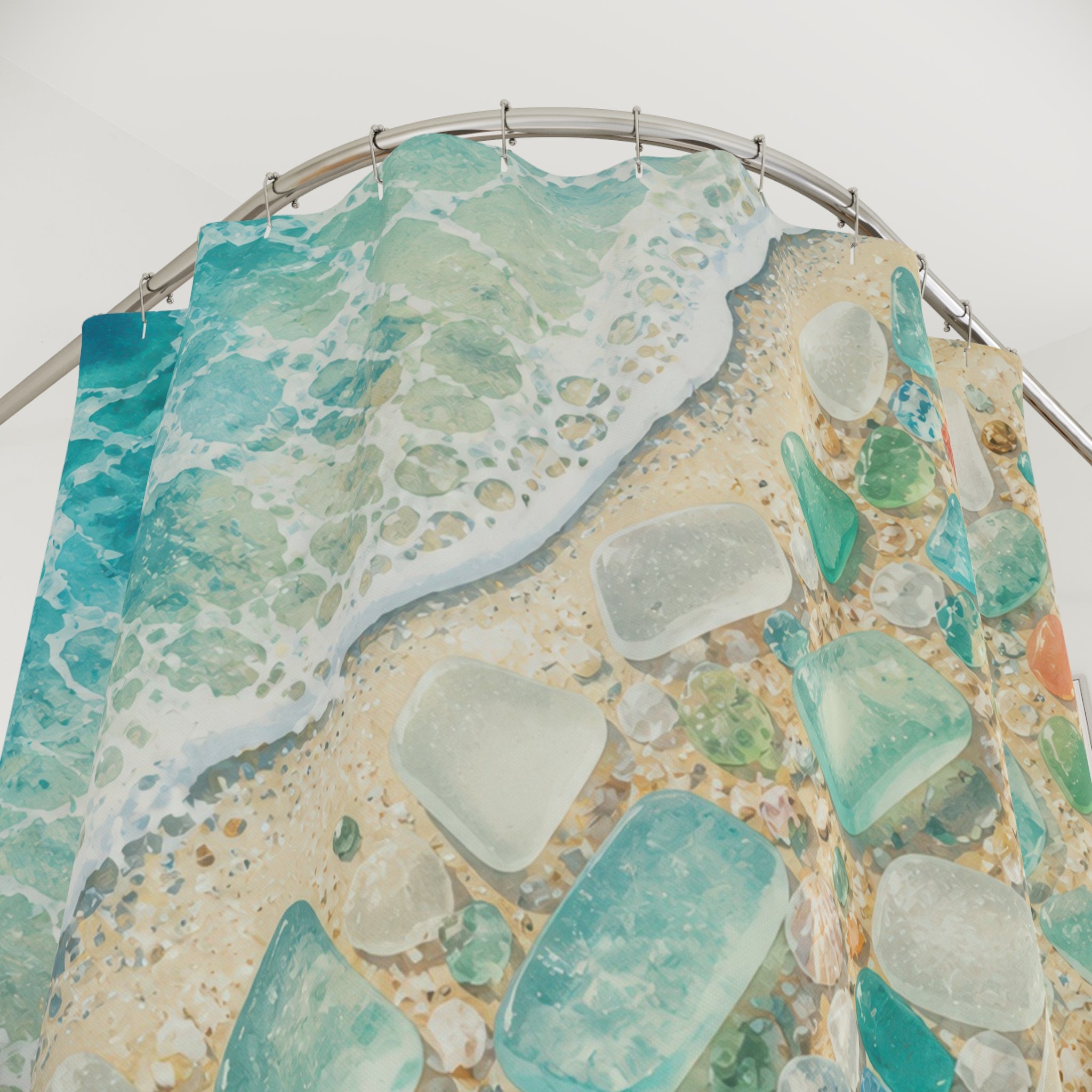 Close-up of Sea glass and shells beside a turquoise shoreline shower curtain with hooks and folds