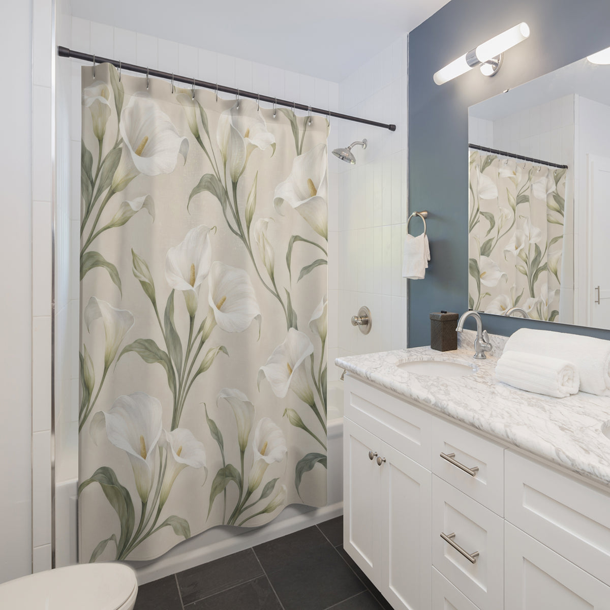 White calla lilies with sage leaves on pale ivory shower curtain beside a white vanity