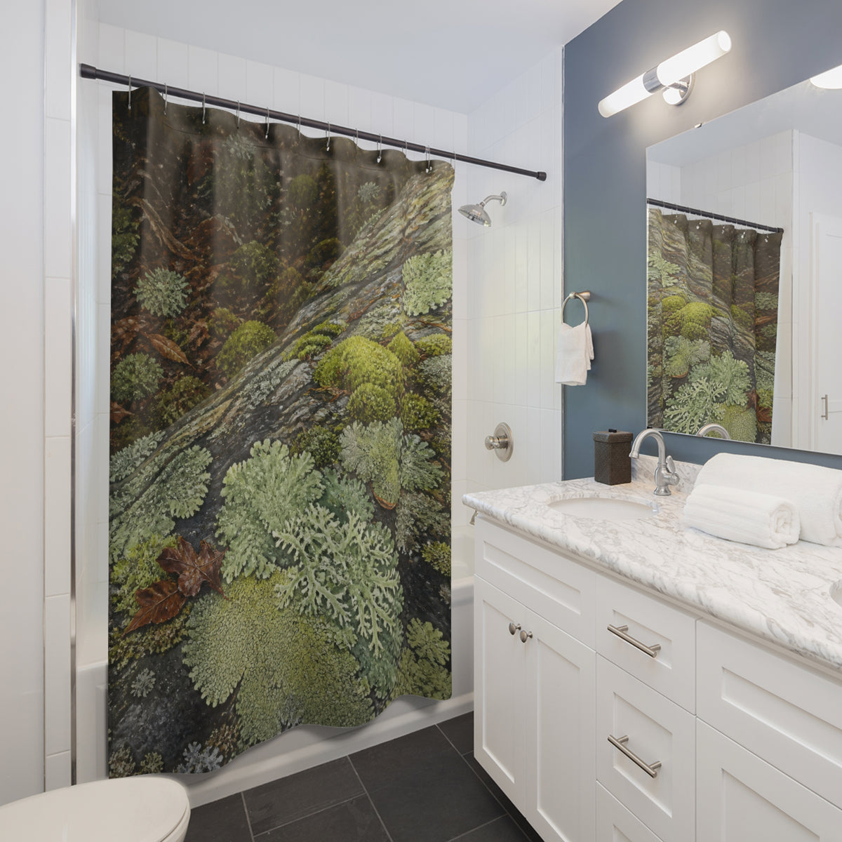 Moss and branching lichen growing across forest stone shower curtain beside a white vanity
