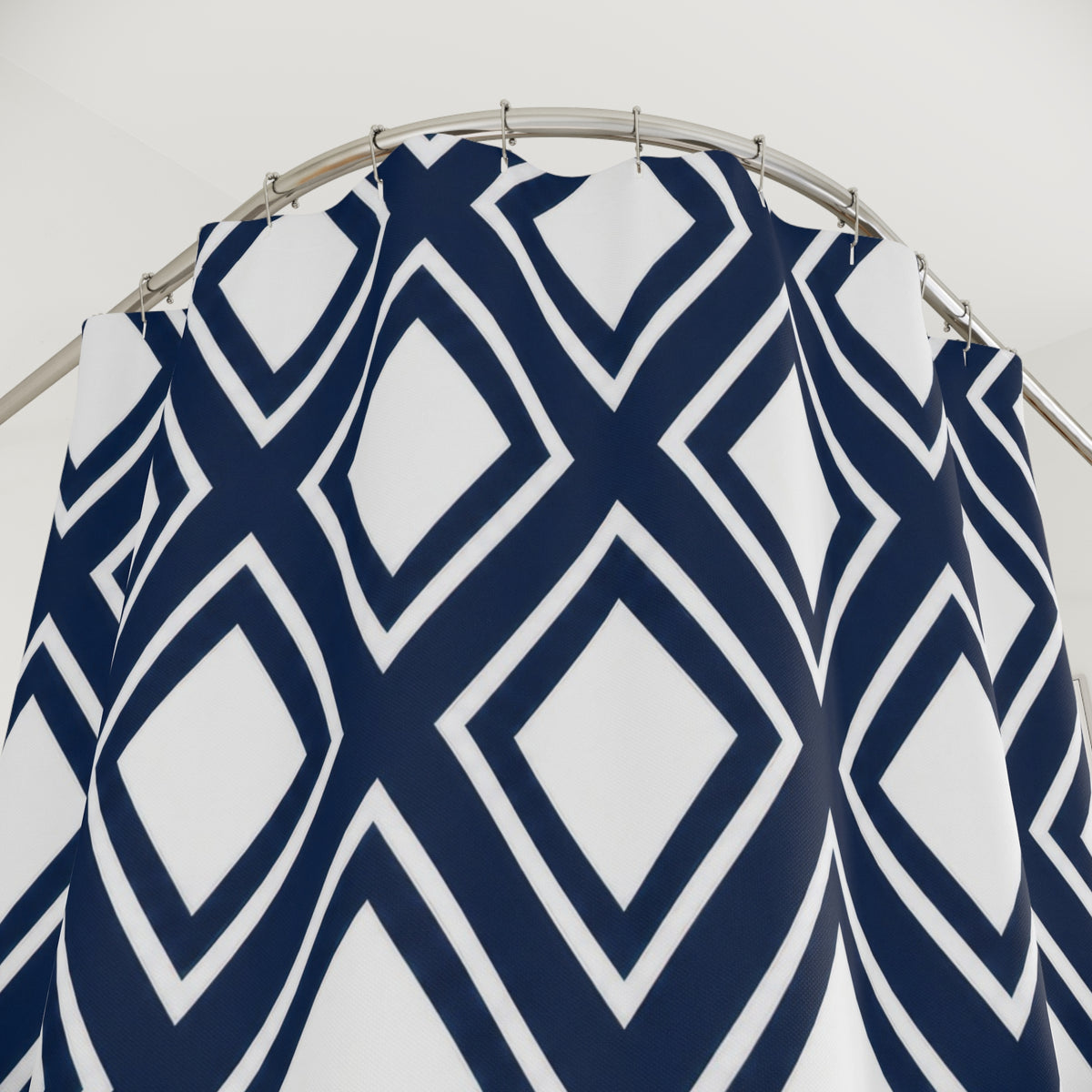 White diamonds in navy lattice with thin white outlines shower curtain with close-up print, hooks, and folds