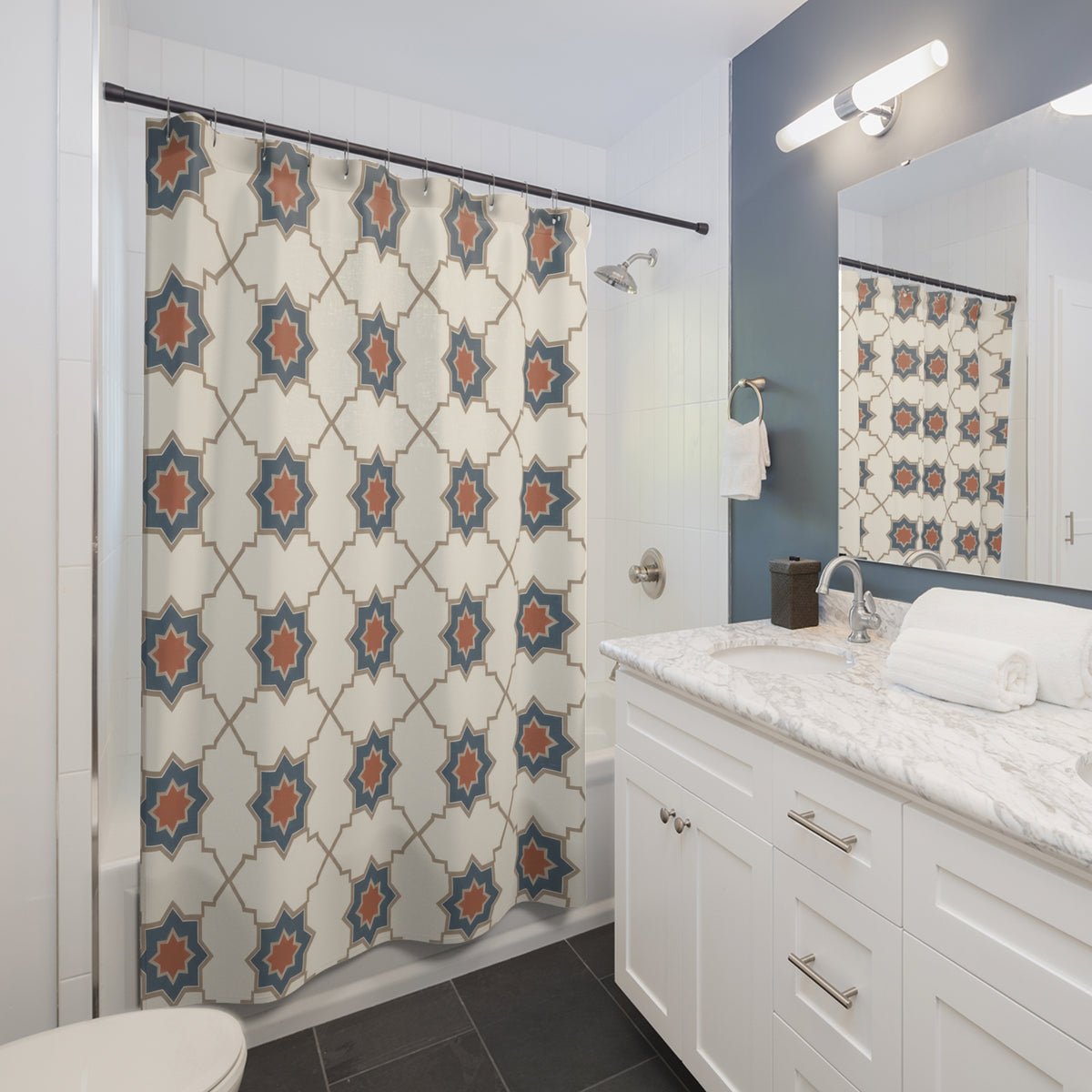 Blue stars with terracotta centers and ivory cross shapes shower curtain beside a white vanity