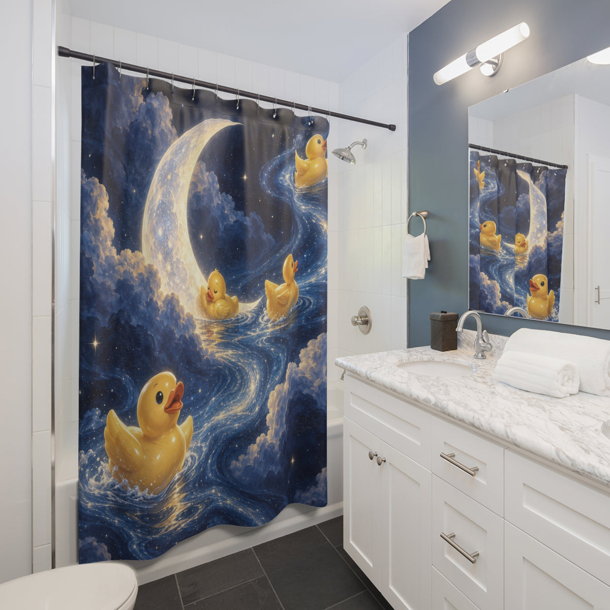 Rubber ducks beneath a moon in a blue starry sky shower curtain beside a white vanity