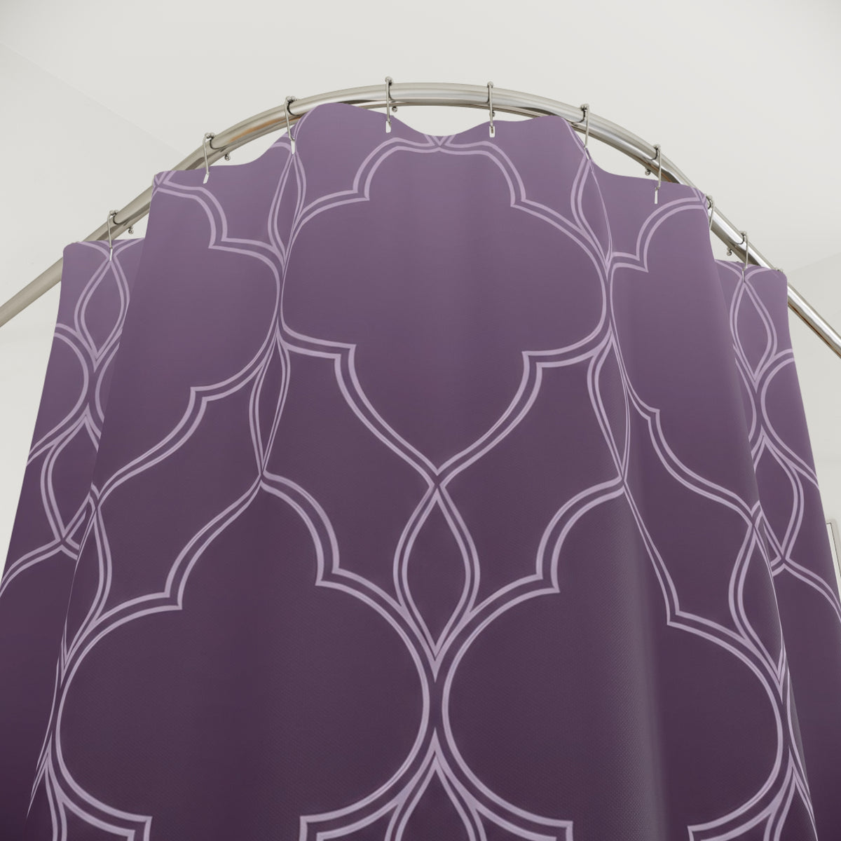 Pale quatrefoil tracery over a lavender to plum ombre shower curtain with close-up print, hooks, and folds