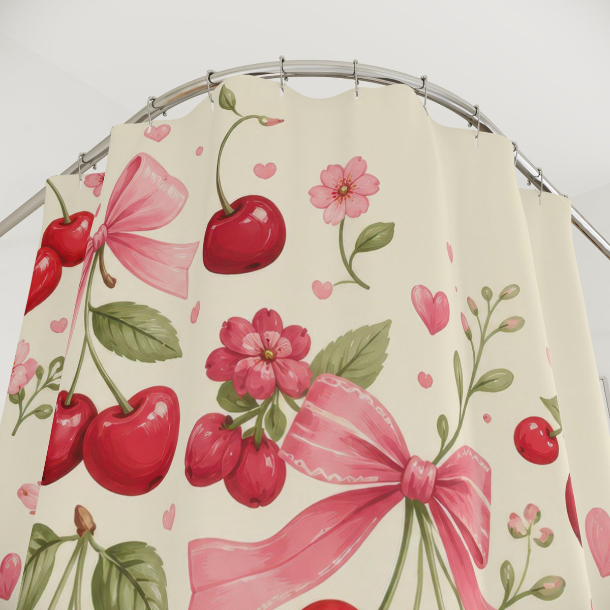 Red cherry clusters and pink bows sweeping across cream shower curtain with close-up print, hooks, and folds