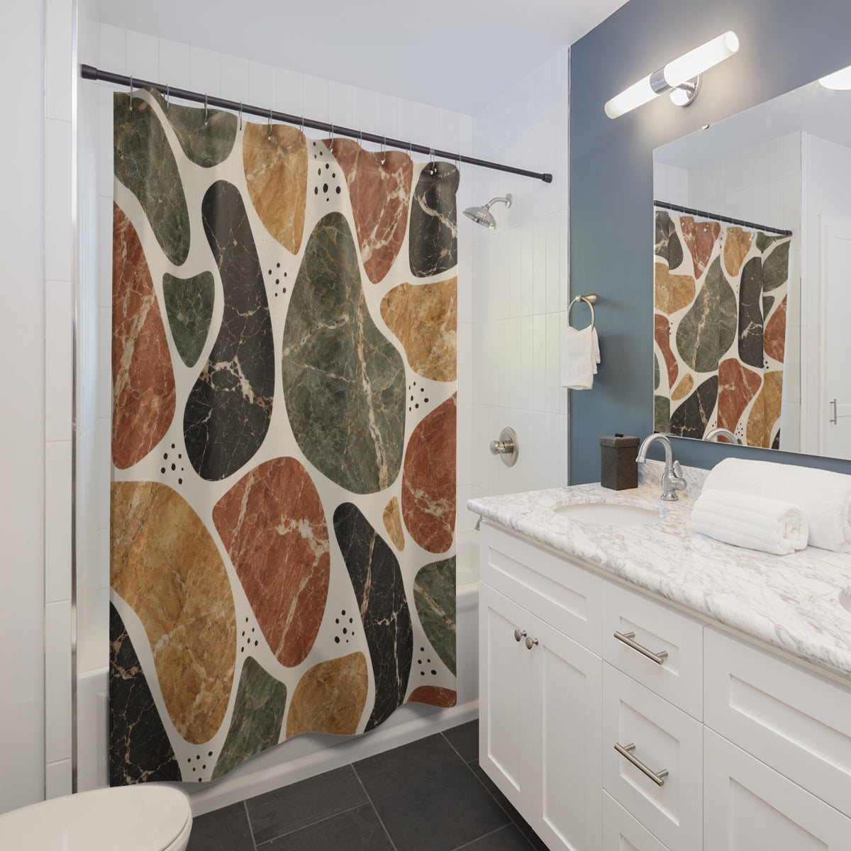 Sage, terracotta, ochre and black marble shapes on cream shower curtain beside a white vanity