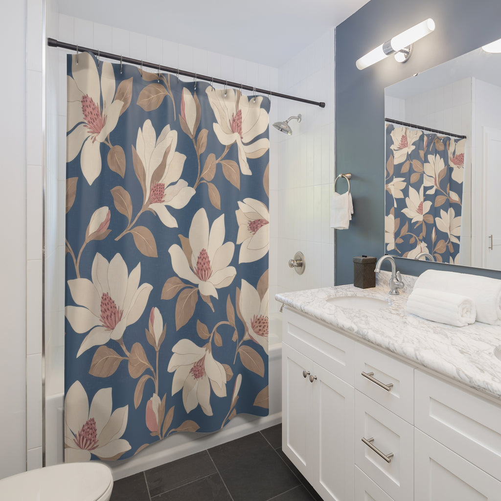 Cream and blush magnolia pattern on slate blue shower curtain beside a white vanity