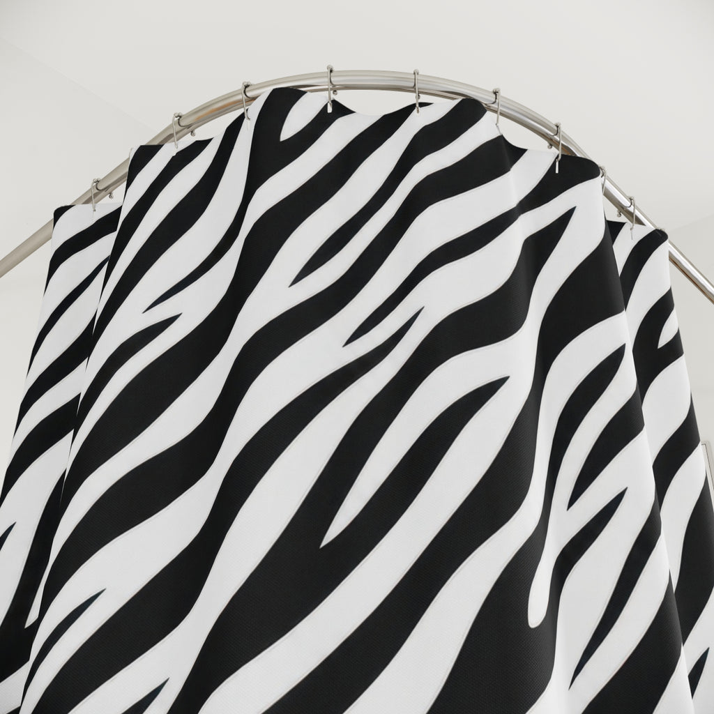 Diagonal black zebra stripes tapering across white shower curtain with close-up print, hooks, and folds
