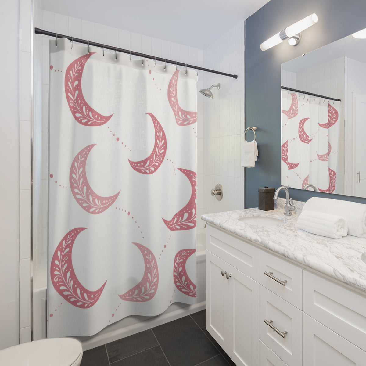 Pink crescent moons with white sprigs and dotted trails shower curtain beside a white vanity