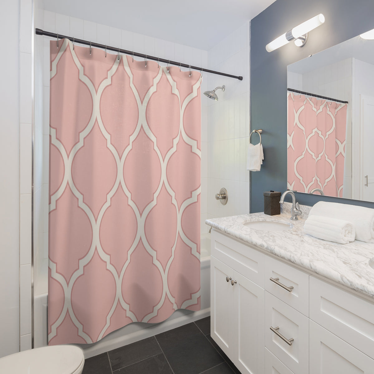 Blush pink and ivory repeating ogee curves shower curtain beside a white vanity