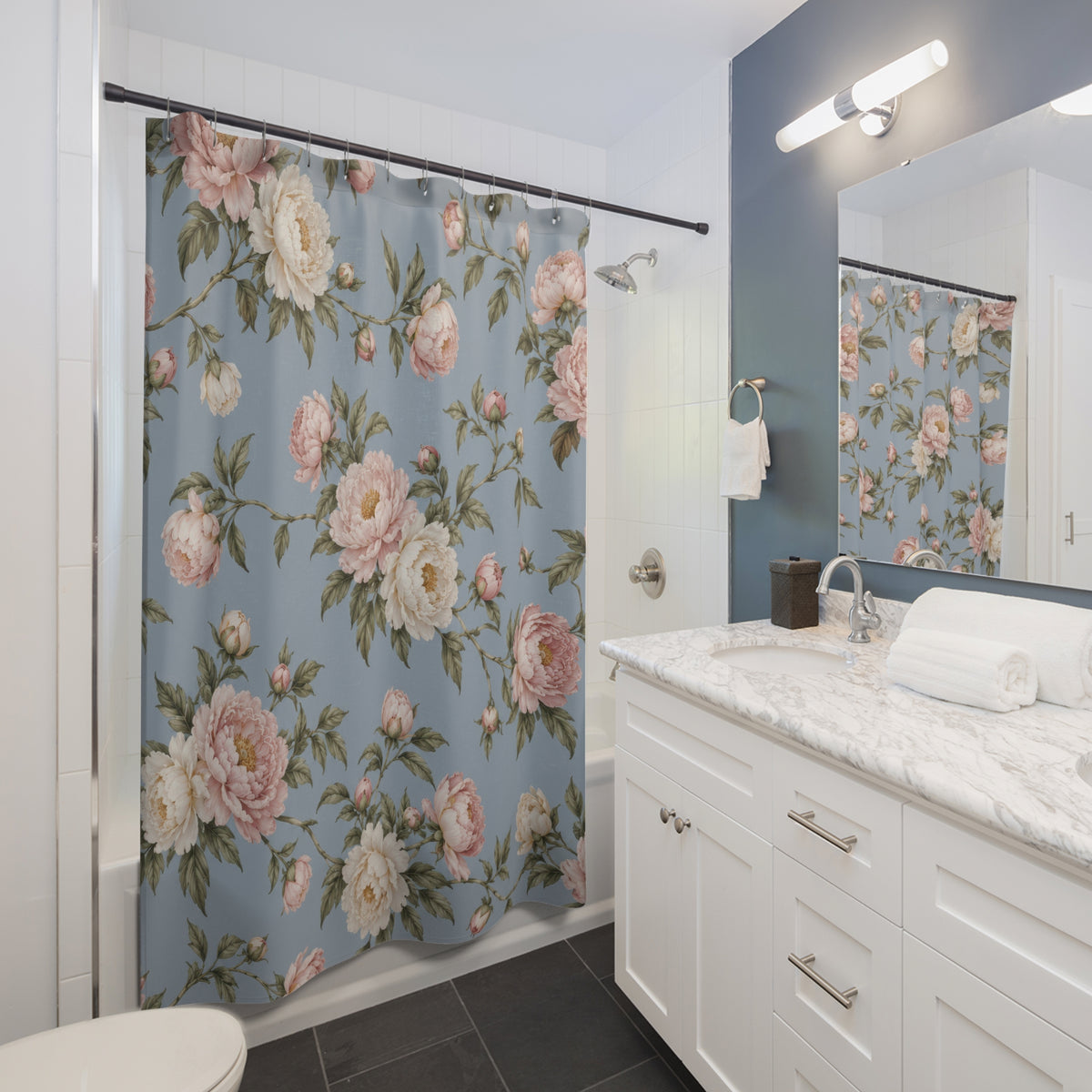 Blush and ivory peonies on dusty blue shower curtain beside a white vanity