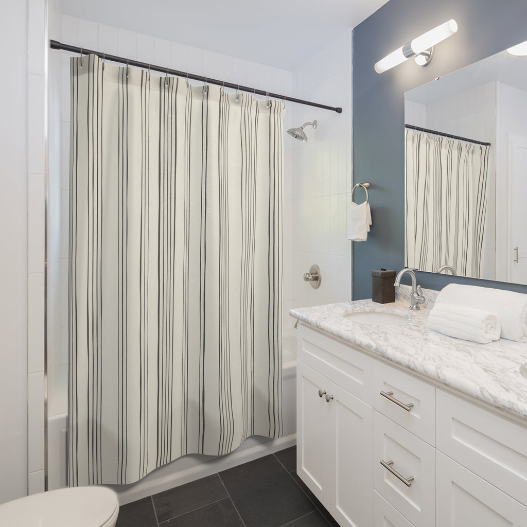 Fine charcoal vertical line bundles on warm ivory shower curtain beside a white vanity
