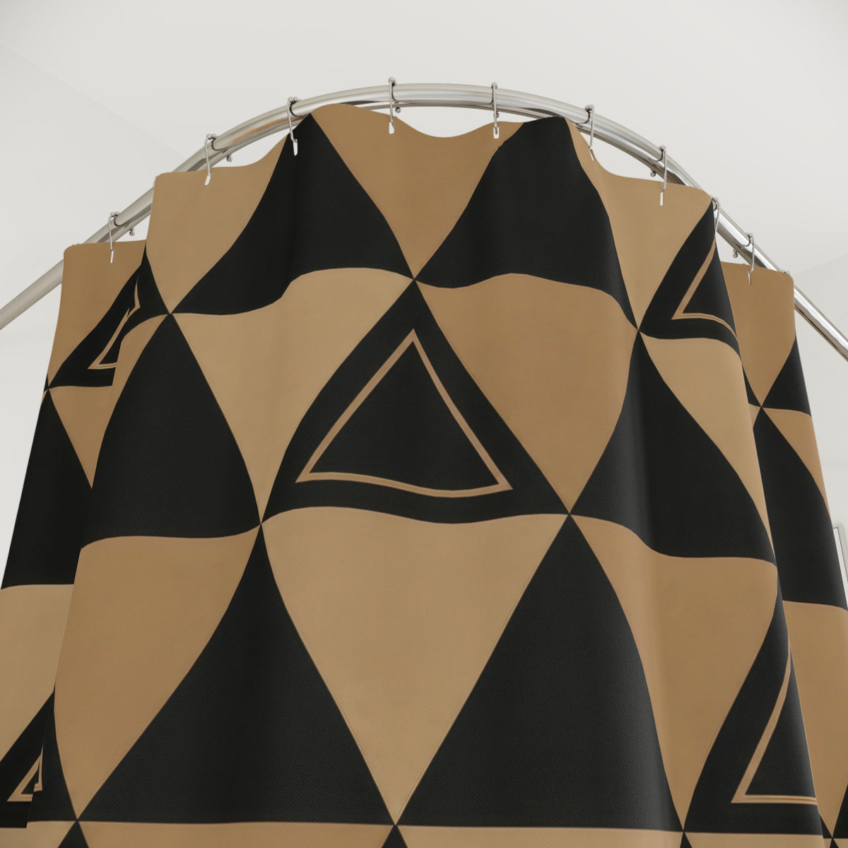 Black and tan geometric triangle shower curtain with close-up print, hooks, and folds