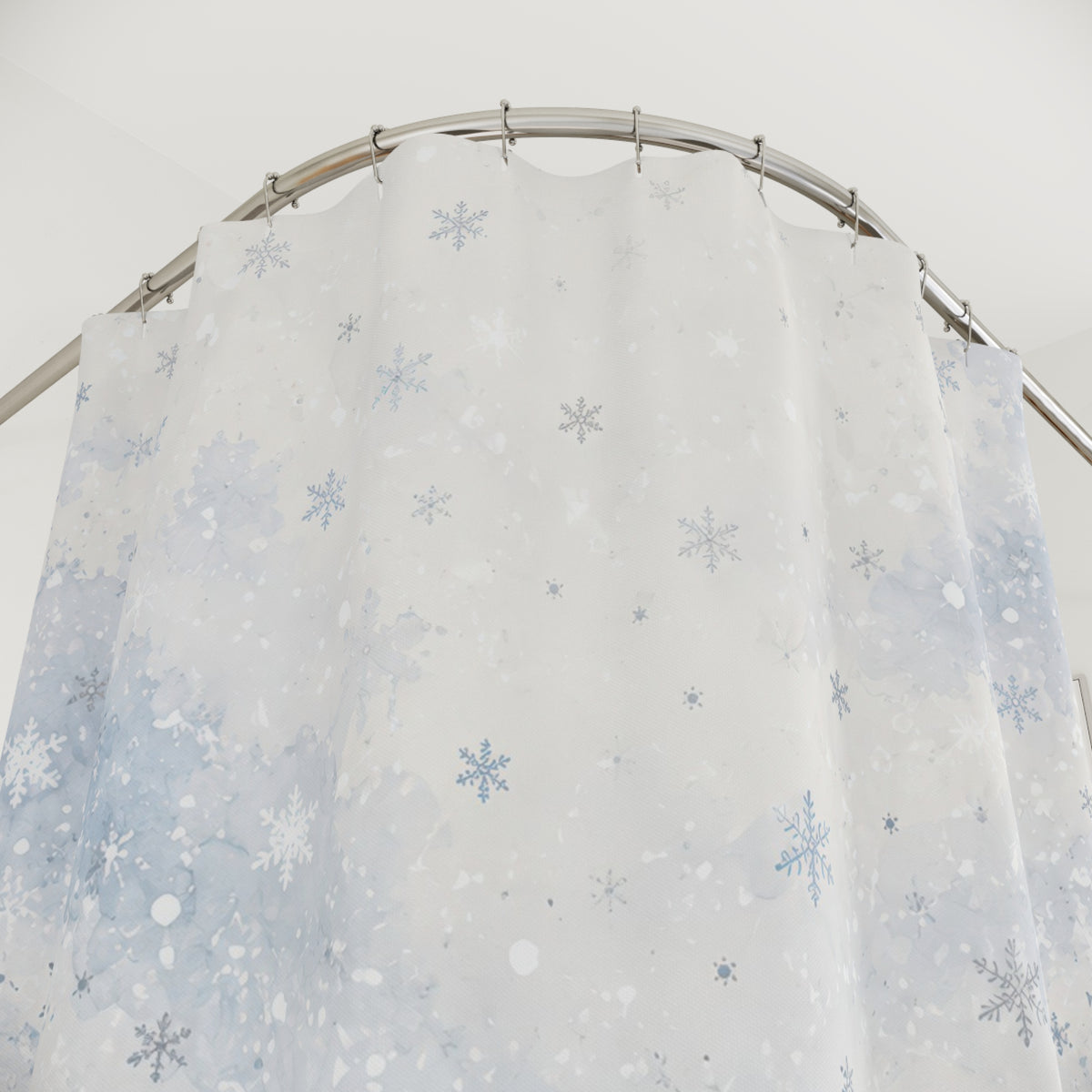 Pale blue watercolor snowfall shower curtain with close-up print, hooks, and folds