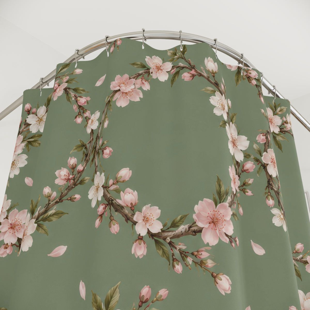 Cream and pink cherry blossom wreaths on sage green shower curtain with close-up print, hooks, and folds