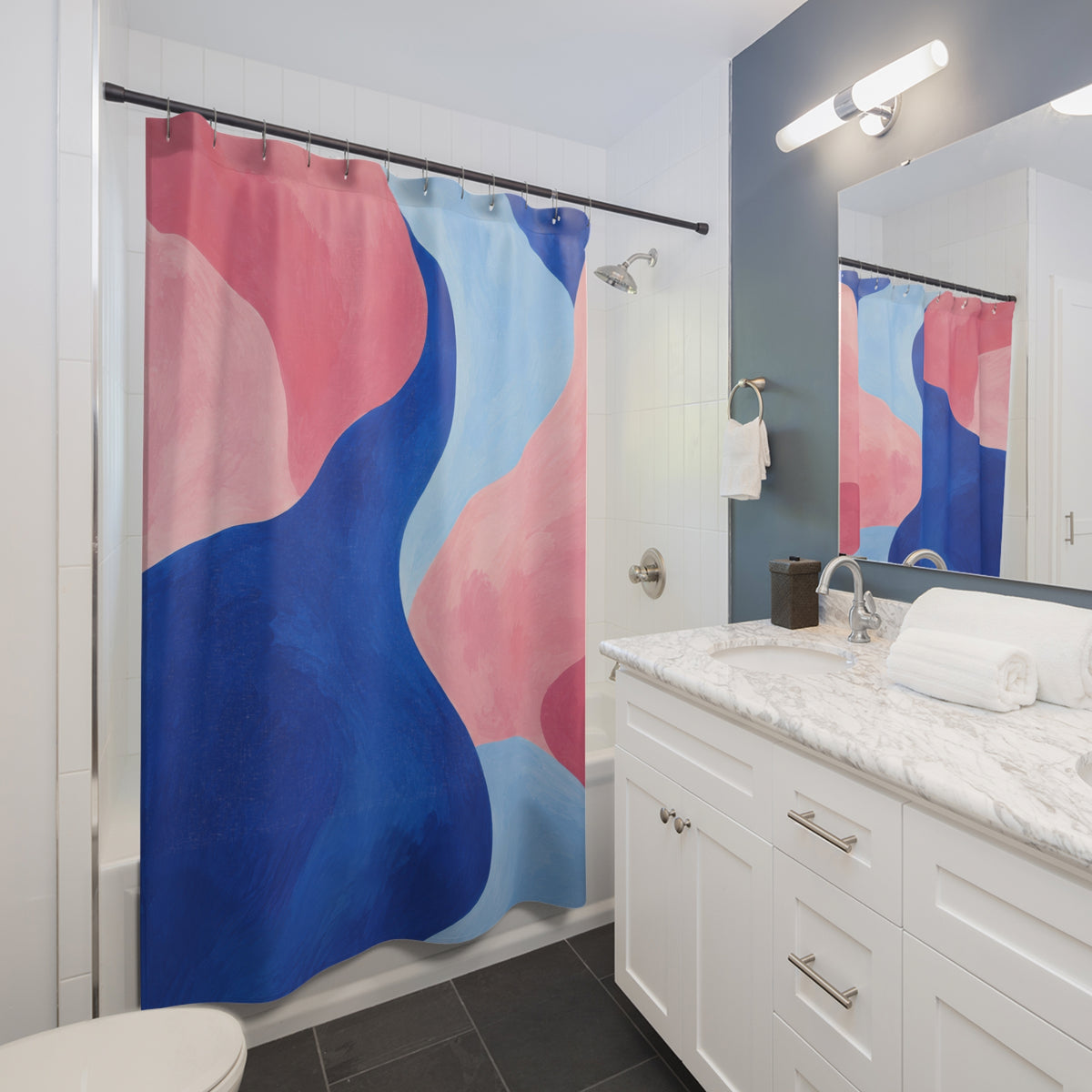 Cobalt blue curves between pink and pale blue abstract shapes shower curtain beside a white vanity
