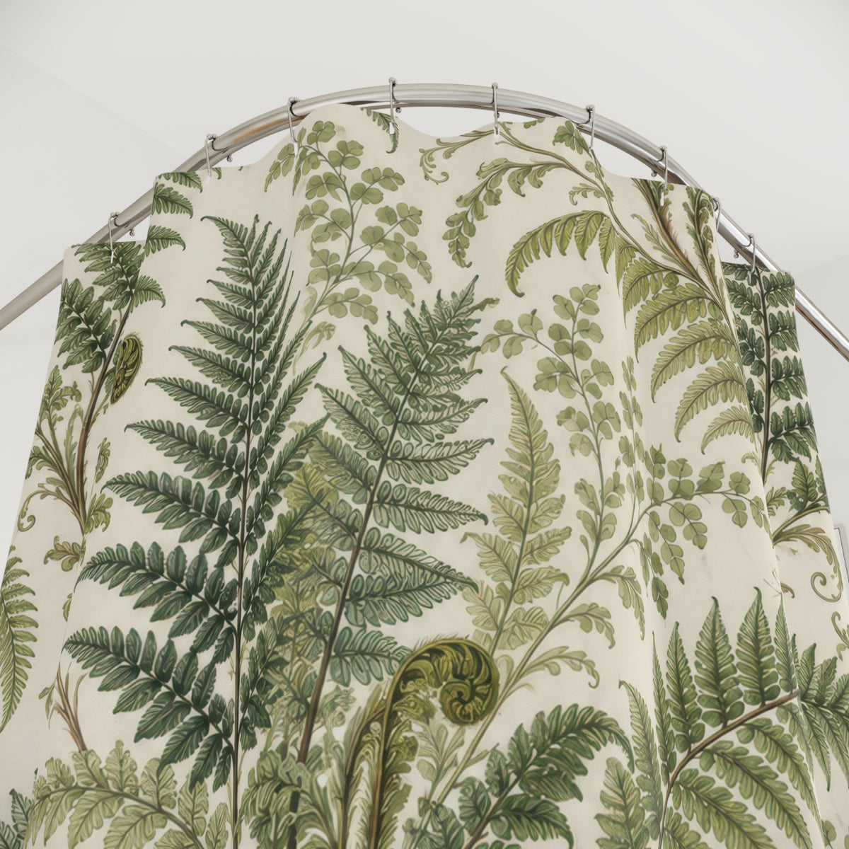 Green fern fronds and curled fiddleheads on ivory shower curtain with close-up print, hooks, and folds