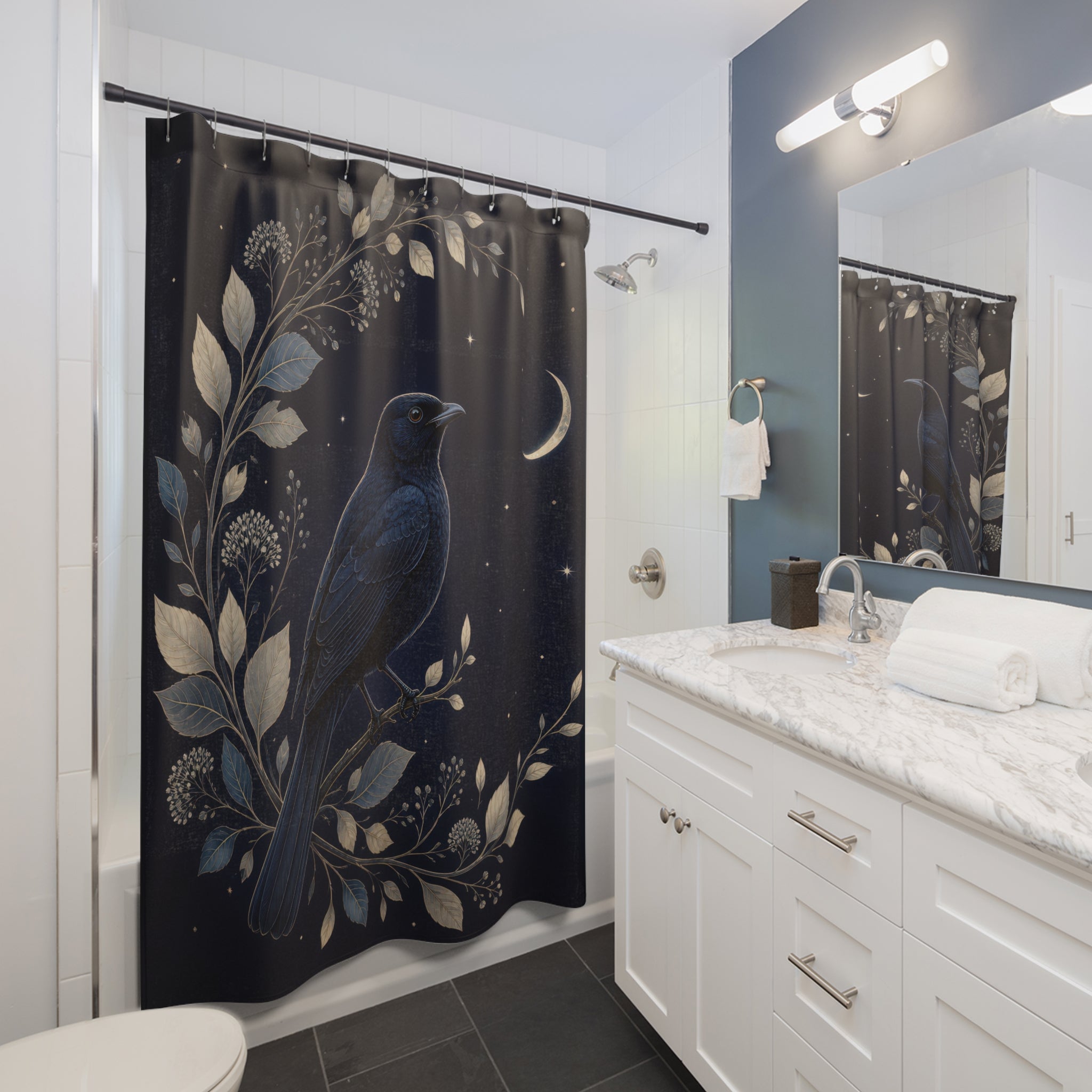 Blackbird framed by silver botanicals and a crescent moon shower curtain beside a white vanity