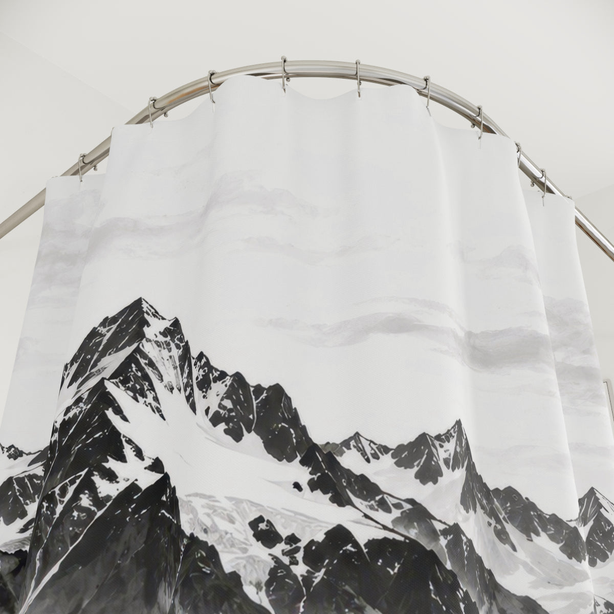 Snowy black and gray mountains reflected in a pale lake shower curtain with close-up print, hooks, and folds