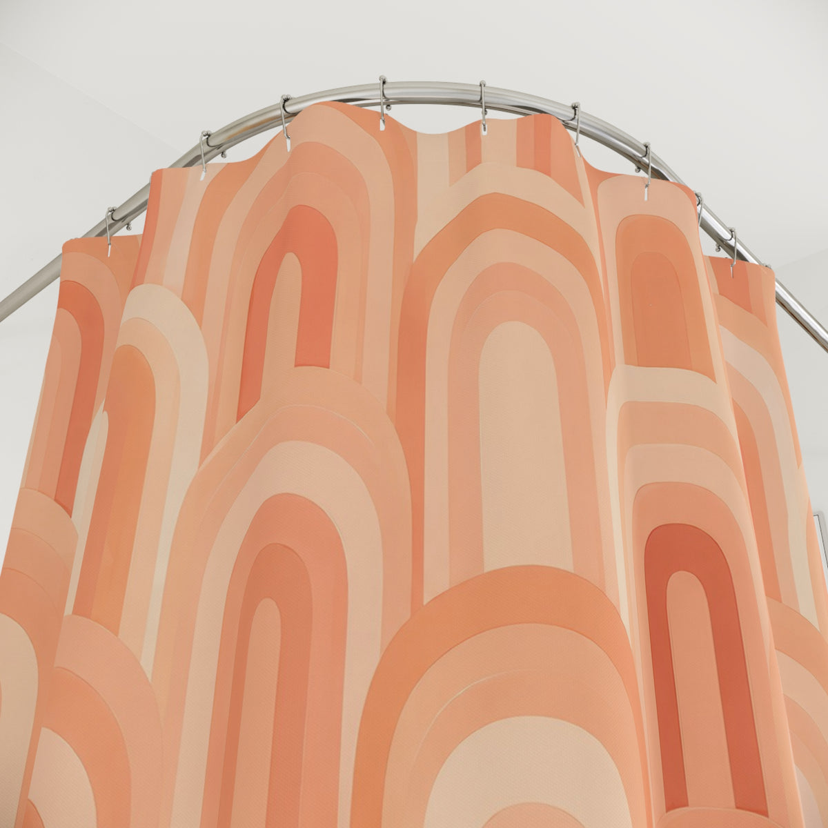 Peachy apricot and cream arches shower curtain with close-up print, hooks, and folds