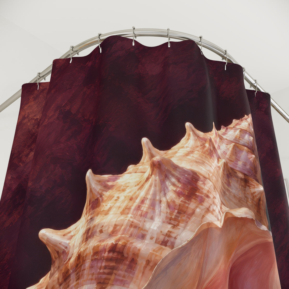 Peach conch shell with a pink opening on deep plum shower curtain with close-up print, hooks, and folds