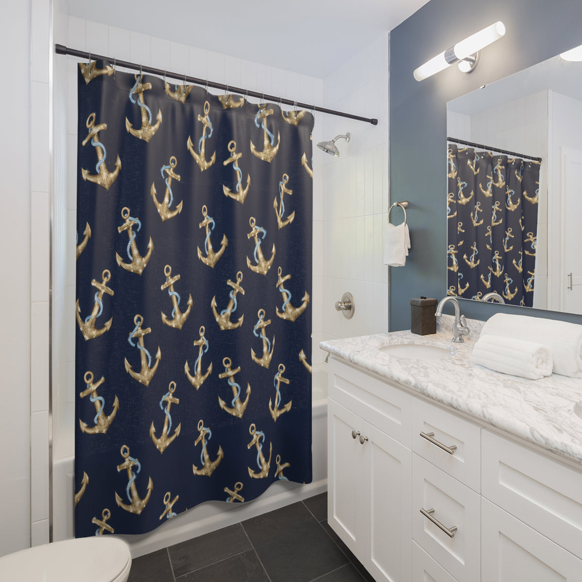 Gold-colored anchors and blue ropes on navy shower curtain beside a white vanity