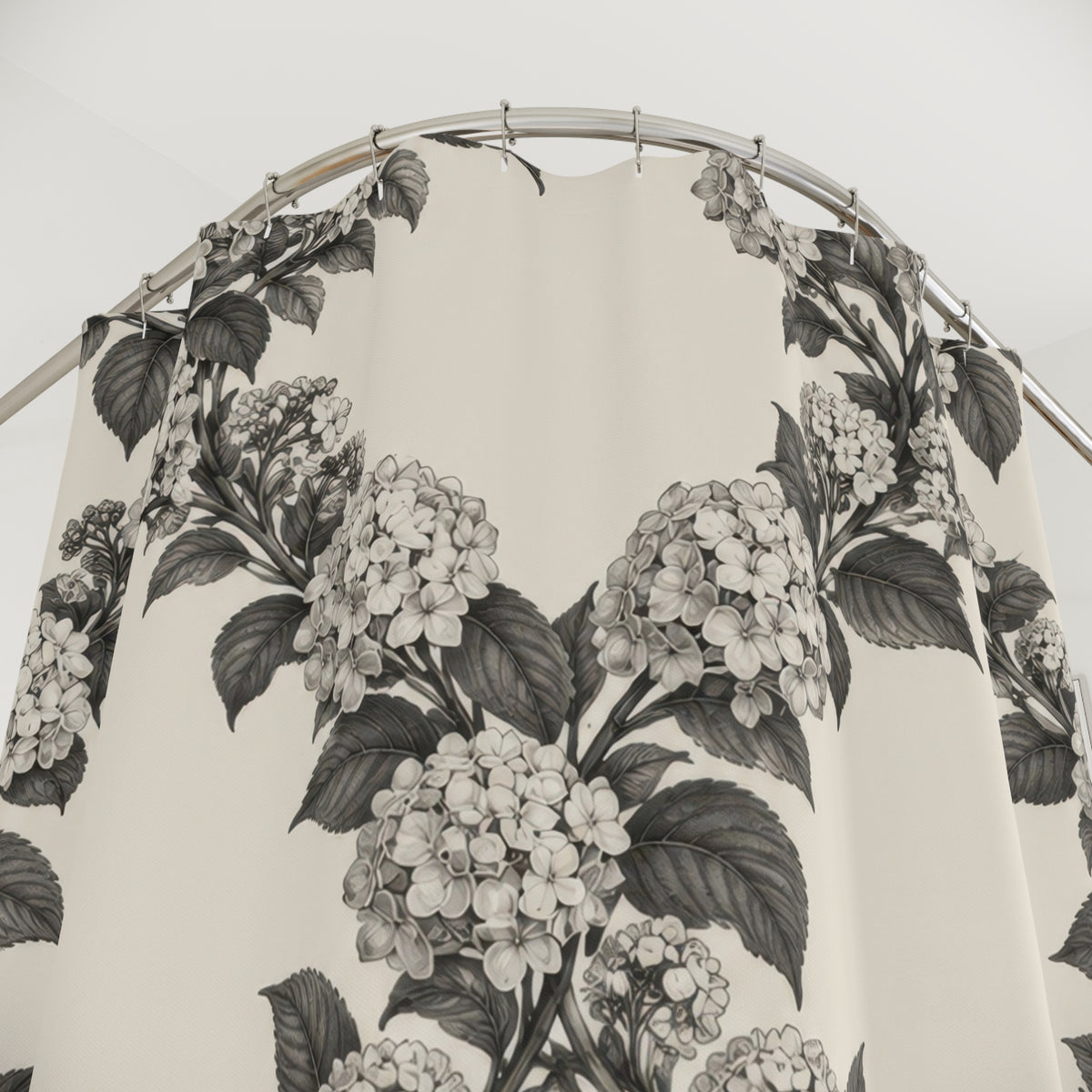 Charcoal hydrangea wreaths and leaves on warm cream shower curtain with close-up print, hooks, and folds