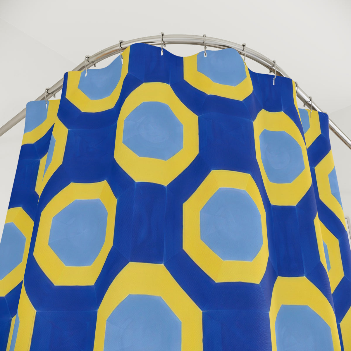 Yellow octagonal bands and pale blue centers on cobalt shower curtain with close-up print, hooks, and folds
