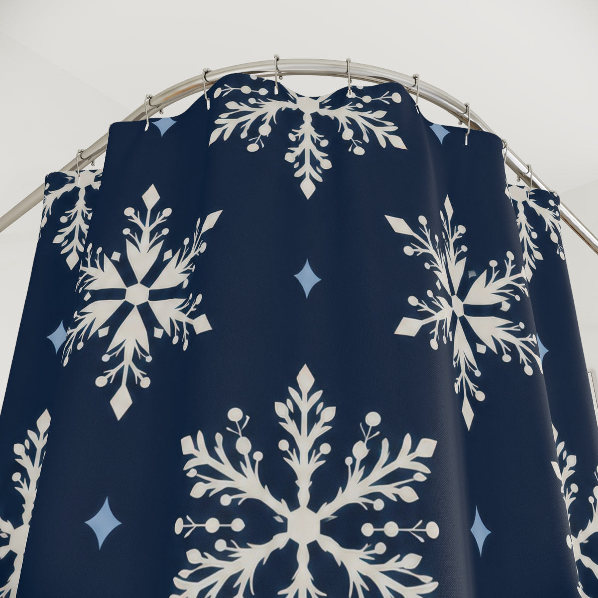 Ivory snowflakes and pale blue diamonds on navy shower curtain with close-up print, hooks, and folds