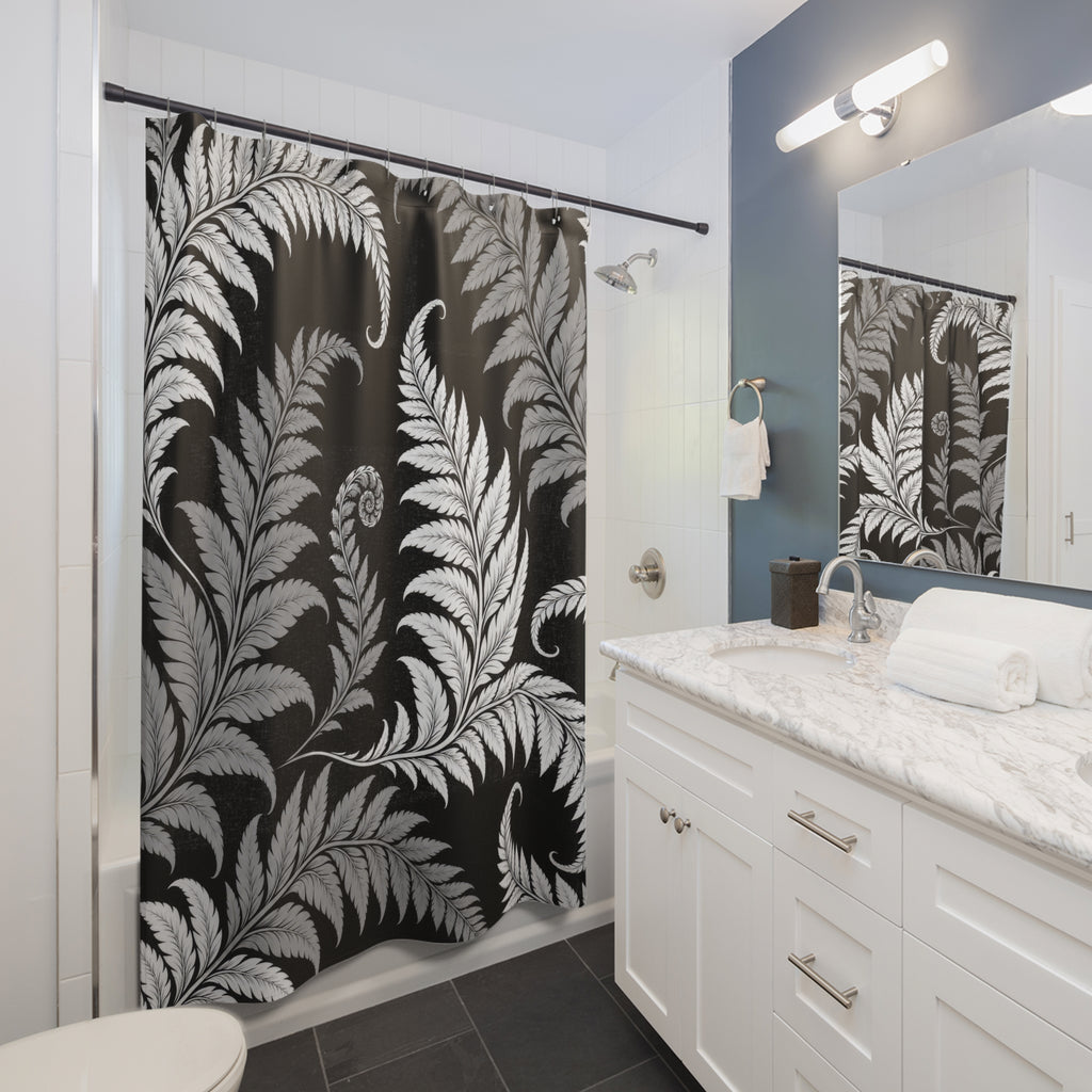 White and gray curling fern fronds on a black ground shower curtain beside a white vanity