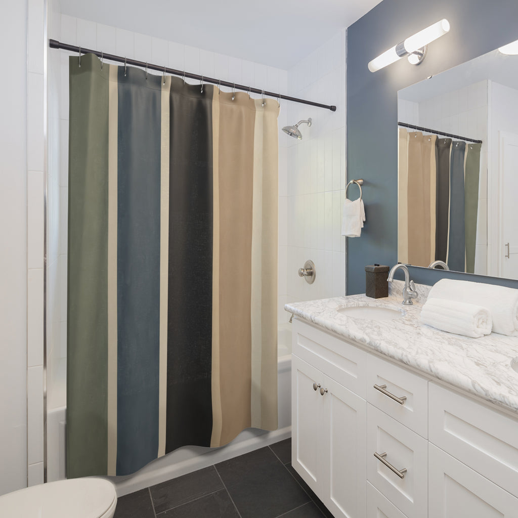 Wide vertical stripes in sage blue charcoal tan and cream shower curtain beside a white vanity