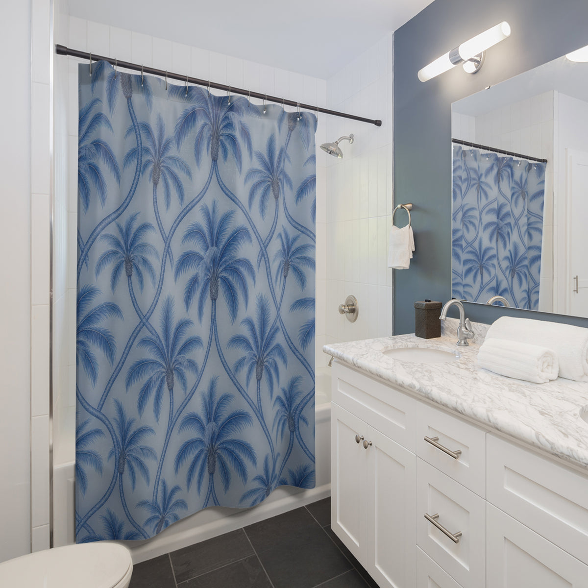 Blue palm trees with interlaced trunks on pale blue shower curtain beside a white vanity
